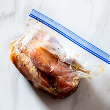 Pork chops with marinade in a resealable plastic bag.