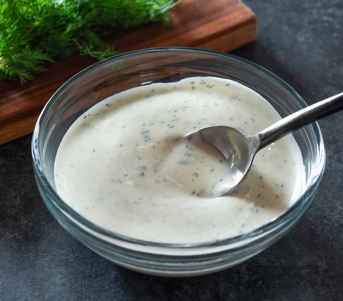 Buttermilk sauce in a bowl with a spoon.