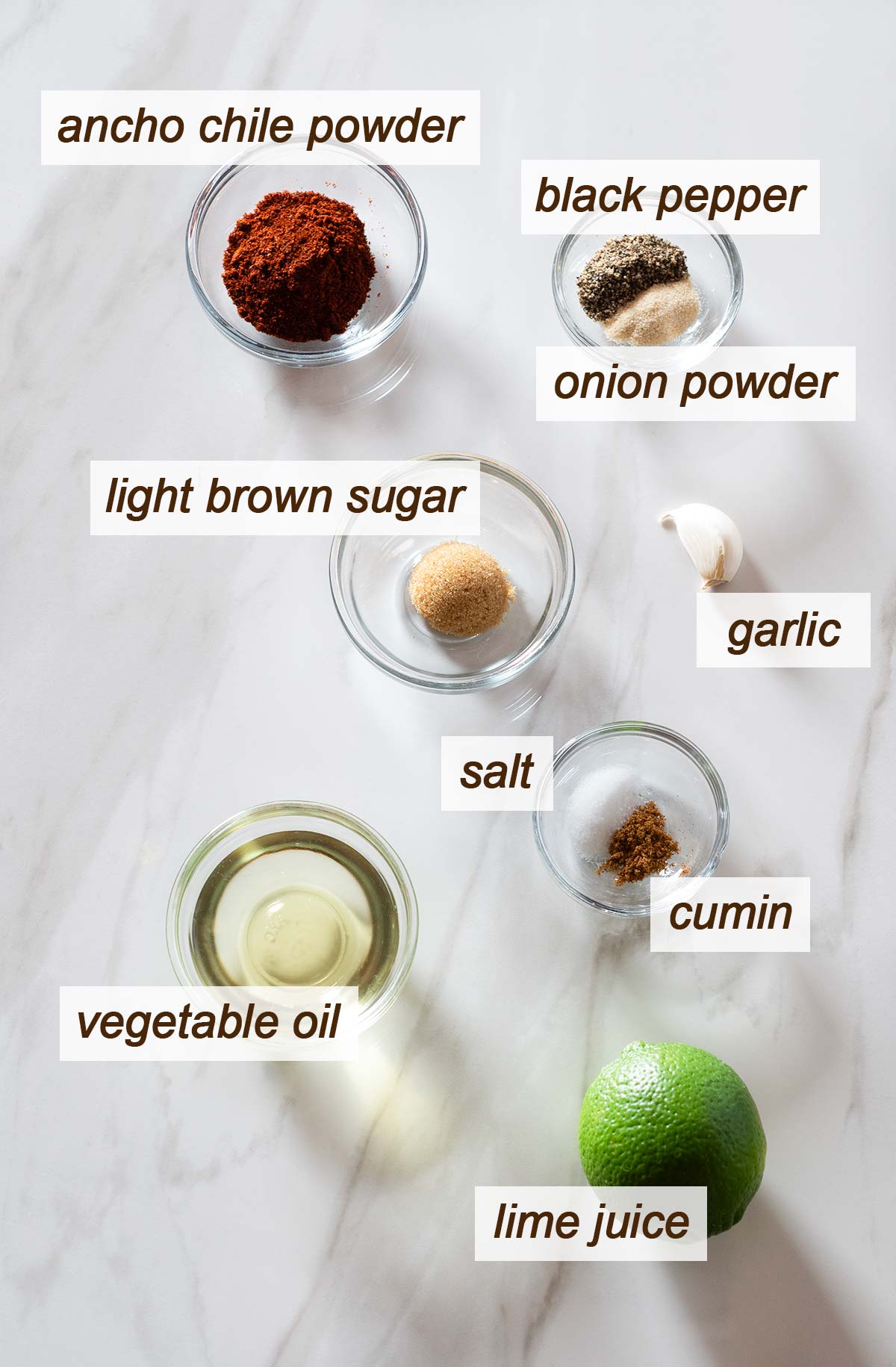 Ancho chile powder, pepper, onion powder, brown sugar, garlic, salt, cumin, oil and lime.