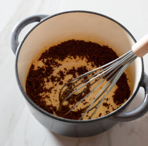 Spices being whisked into a roux.