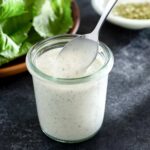 Italian salad dressing in a jar with a spoon.