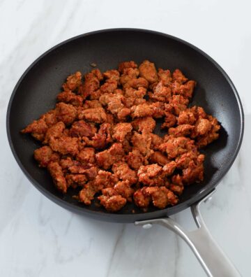 Cooked Italian sausage with paprika in a pan.