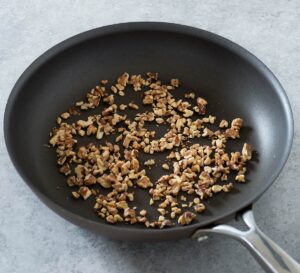 Chopped walnuts in a skillet.