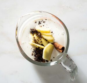 Spices and cream in a liquid measuring cup.