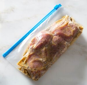 Pork tenderloin with marinade in a bag.