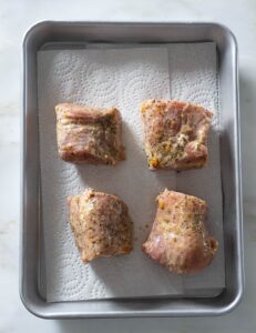 Marinated pork tenderloin on paper towels.