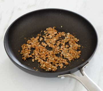 Cooked onion and spices in a pan.