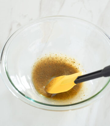 Oil and seasonings being mixed in a bowl.