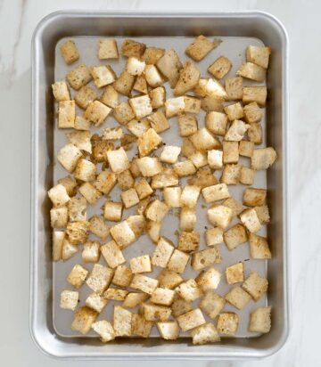 Bread cubes on a baking sheet.