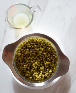 Drained, canned peas in a colander.