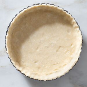 Unbaked pie crust in a tart pan.