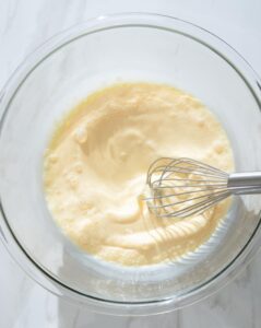 Eggs and milk being whisked in a bowl.