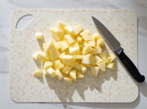 Apple chunks on a cutting board.