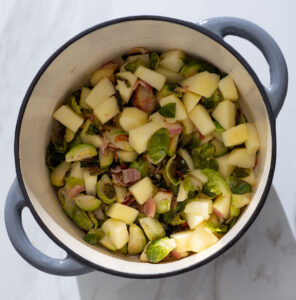 Brussels sprouts, bacon and apple in a Dutch oven.