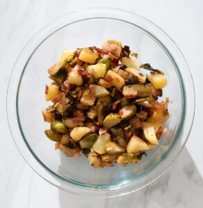 Roasted Brussels sprouts, bacon and apple in a bowl.